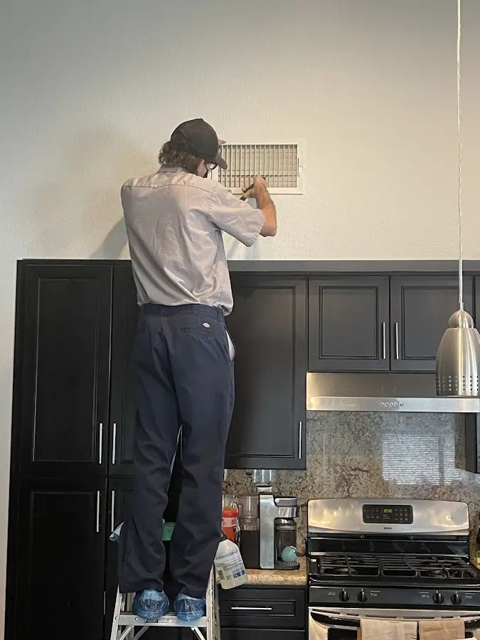 Technician inspecting an air vent during HVAC service in Port Hueneme